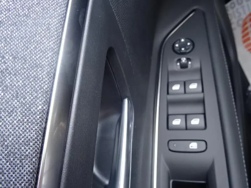 Vue rapprochée de la commande des vitres électriques côté conducteur du Peugeot 3008 gris clair de 2019.