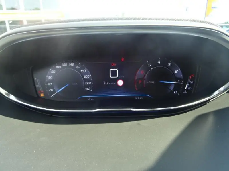 Gros plan sur le tableau de bord numérique du Peugeot 3008 gris clair, affichant vitesse et compte-tours.