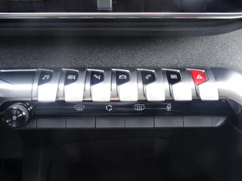 Gros plan sur les commandes type piano en aluminium brossé du tableau de bord d'une Peugeot 3008 gris clair de 2019.