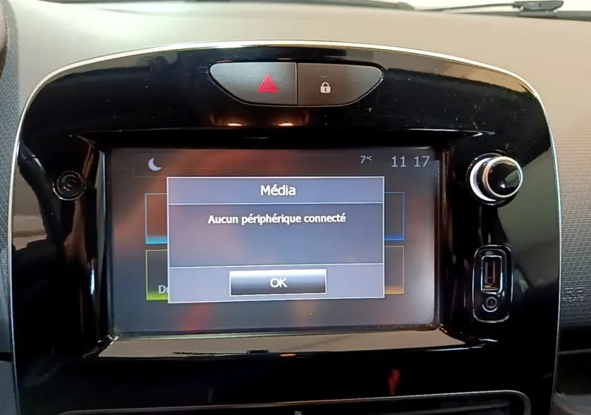 Vue rapprochée de l’écran tactile multimédia noir brillant du tableau de bord de la Renault Clio blanche Zen Energy dCi 75.