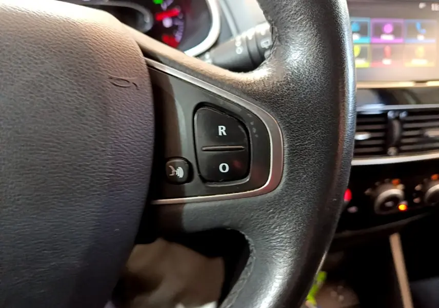 Gros plan sur le volant cuir noir de la Renault Clio Zen Energy dCi 75, avec commandes multifonctions visibles.