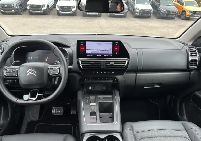 Vue intérieure avant du Citroën C5 Aircross Hybrid blanc, avec tableau de bord numérique et écran tactile central.