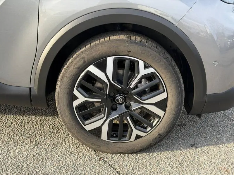 Gros plan sur la roue avant gauche de la Citroën C4 X 2025 gris Mercury avec jante alliage au design géométrique.