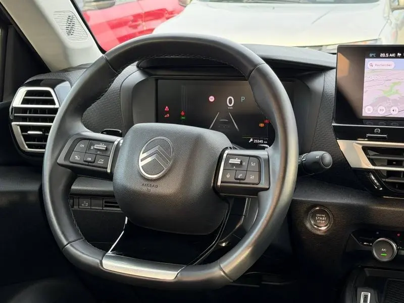 Vue rapprochée du volant cuir noir de la Citroën C4 X 2025 avec tableau de bord digital et écran tactile latéral.