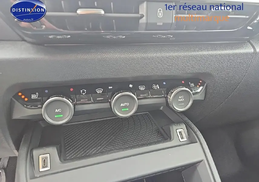 Vue rapprochée de la console centrale de la Citroën C4 bleu eclipse, montrant les commandes de climatisation et prises USB.