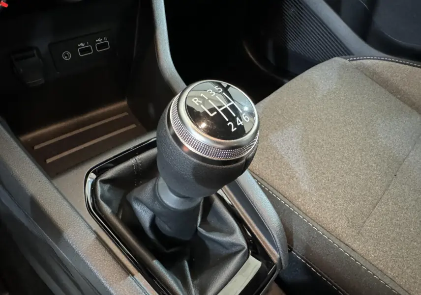 Le levier de vitesses manuel de la Renault Clio gris clair, vue rapprochée de la console centrale et siège passager.