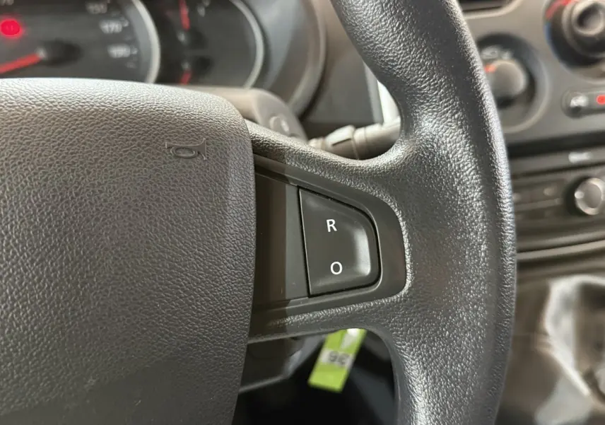 Gros plan sur le volant noir du Renault Kangoo 2021, avec boutons R et O visibles sur la partie droite.