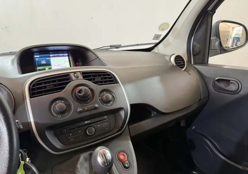 Intérieur du Renault Kangoo blanc 2021, vue côté passager sur tableau de bord avec écran tactile et levier de vitesse manuel.
