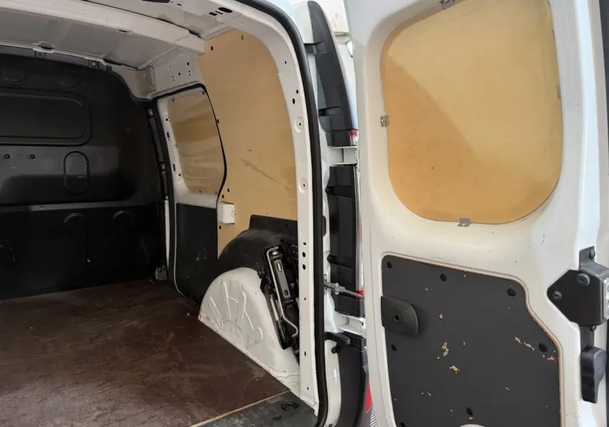Vue intérieure arrière droite du Renault Kangoo Extra R-Link blanc, montrant l'espace de chargement avec cloison bois.