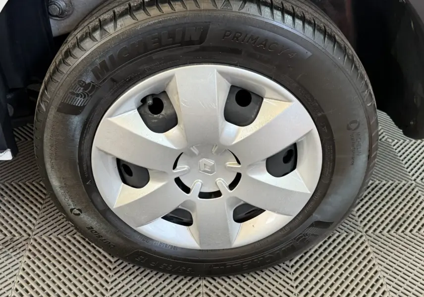 Gros plan sur la roue avant avec jante en acier et enjoliveur argenté du Renault Kangoo blanc 2021.