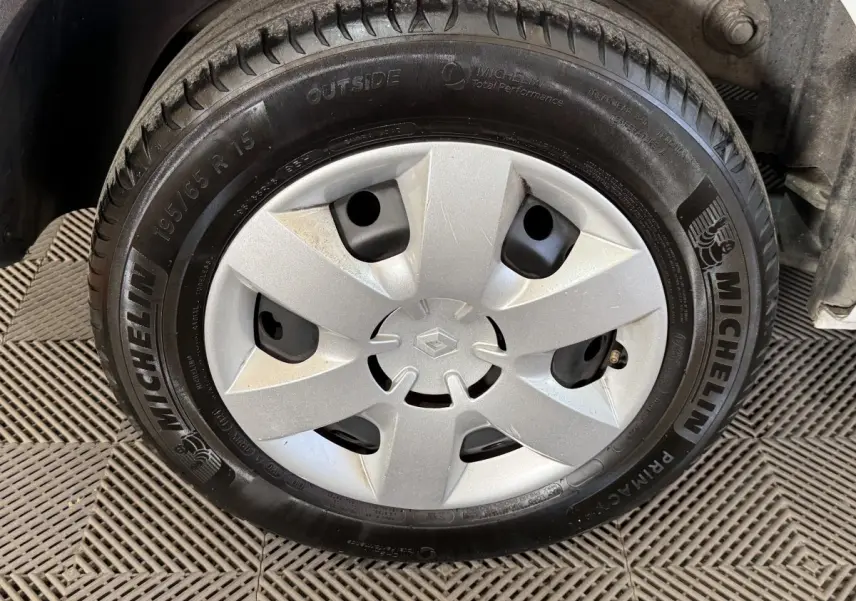 Gros plan sur la roue avant droite d’un Renault Kangoo blanc avec enjoliveur argenté et pneu Michelin.