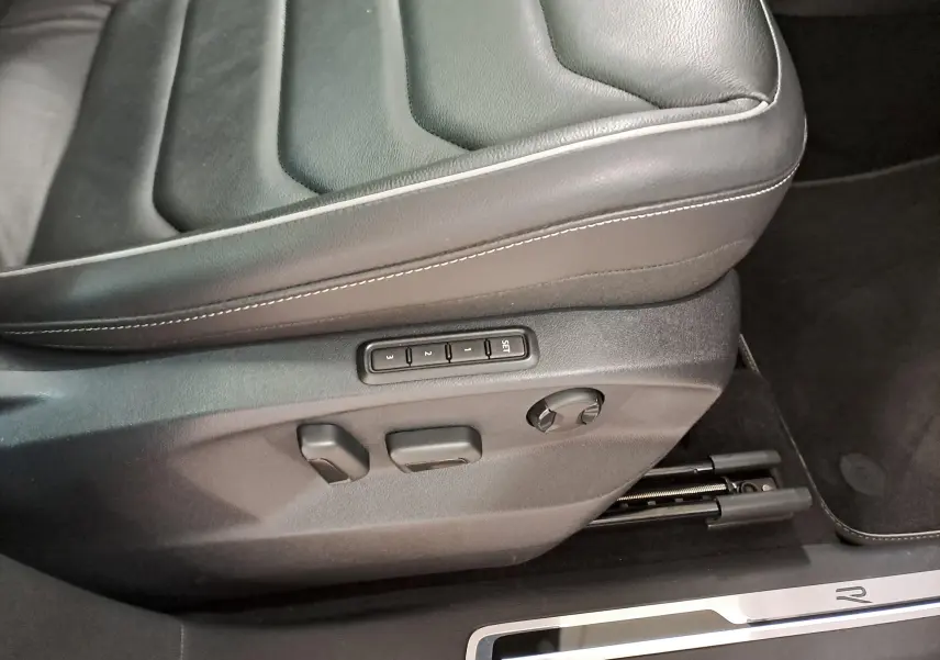 Gros plan sur les commandes de réglage électrique du siège conducteur en cuir noir du Volkswagen Tiguan 1.4 eHybrid 2023.