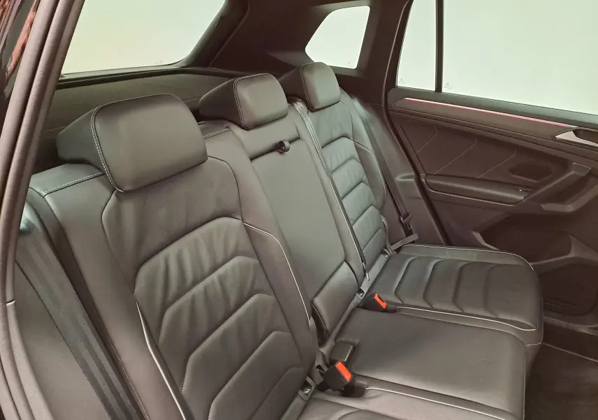 Vue intérieure côté droit des sièges arrière en cuir noir du Volkswagen Tiguan 1.4 eHybrid 2023, avec surpiqûres contrastées.
