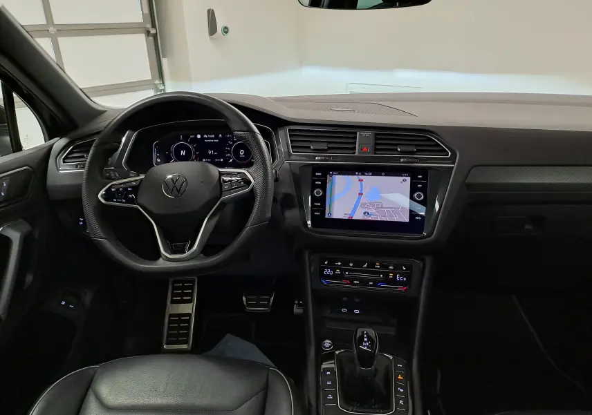 Vue intérieure du tableau de bord du Volkswagen Tiguan 1.4 eHybrid 2023, avec écran tactile et volant multifonction noir.