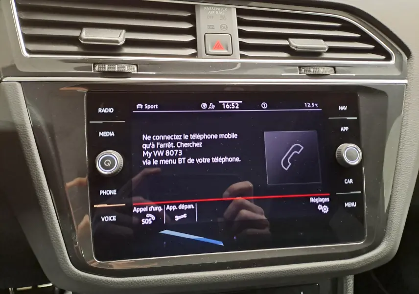 Vue rapprochée de l'écran tactile central du Volkswagen Tiguan 2023 noir intense nacré, affichant les options de connexion téléphone.