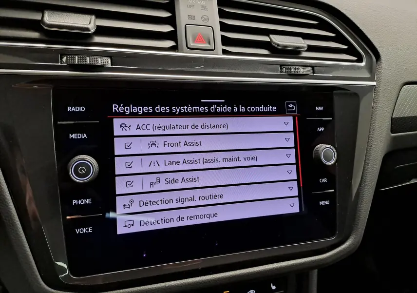 Écran tactile central du Volkswagen Tiguan 1.4 eHybrid 2023 affichant les réglages des aides à la conduite.
