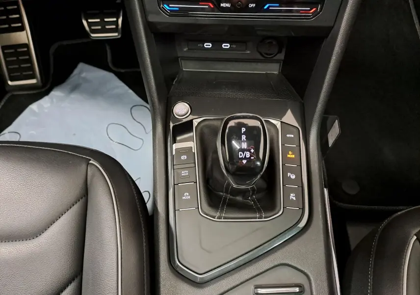 Vue plongeante sur la console centrale du Volkswagen Tiguan 1.4 eHybrid 2023 avec levier de vitesses automatique et boutons de contrôle.