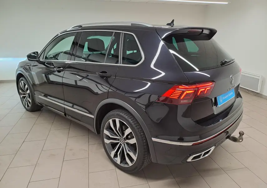Vue 3/4 arrière droite du Volkswagen Tiguan 1.4 eHybrid noir intense nacré avec attelage escamotable et jantes 20 pouces.