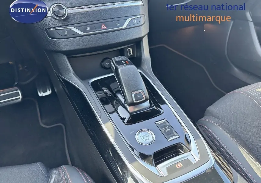 Le levier de vitesse automatique et la console centrale noire brillante de la Peugeot 308 GT blanche nacrée, vue intérieure.