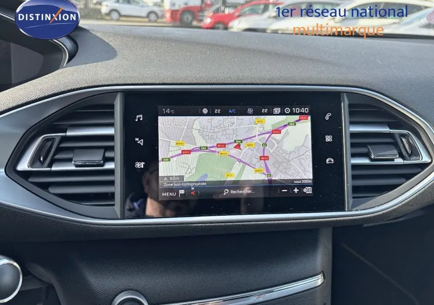 Tableau de bord de Peugeot 308 blanc nacré 2021, vue frontale centrée sur l'écran GPS tactile et les aérateurs.