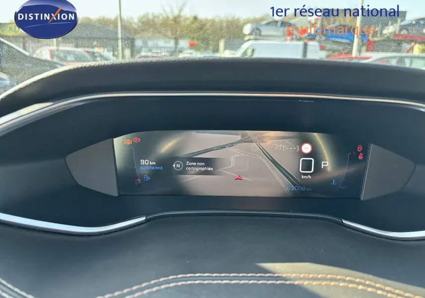 Tableau de bord numérique de Peugeot 308 blanc nacré 2021, affichant la navigation et l'autonomie restante.