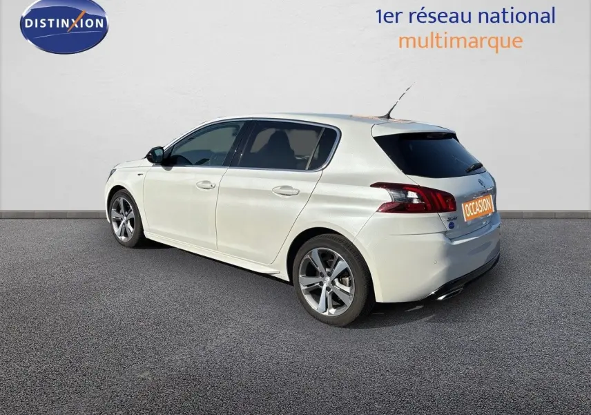 Peugeot 308 blanc nacré vue 3/4 arrière côté gauche, avec jantes alliage et vitres teintées.