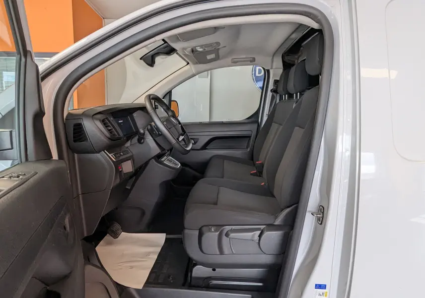 Intérieur du Peugeot Expert Fourgon blanc 2024, vue côté gauche sur les sièges avant noirs et le tableau de bord.