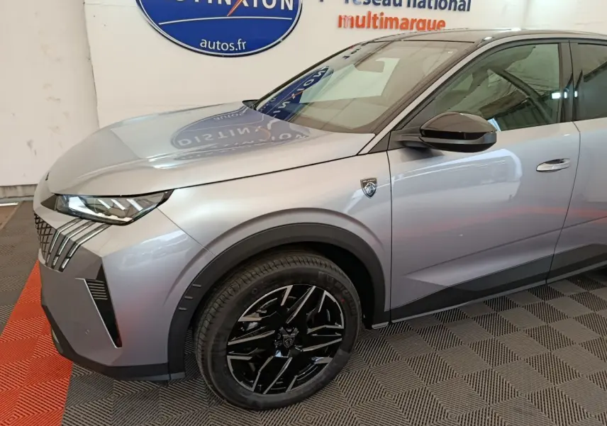 Vue 3/4 avant gauche d'un Peugeot 3008 gris clair avec jantes noires et logo distinctif sur l'aile avant.