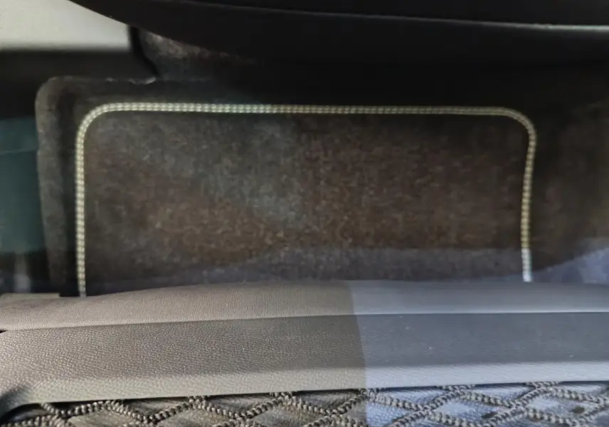 Tapis de sol gris foncé avec surpiqûres claires dans l'habitacle du Peugeot 3008 hybride 2025.