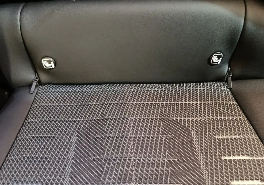 Détail du coffre avec banquette arrière rabattue et fixation Isofix sur Peugeot 3008 gris clair hybride 2025.