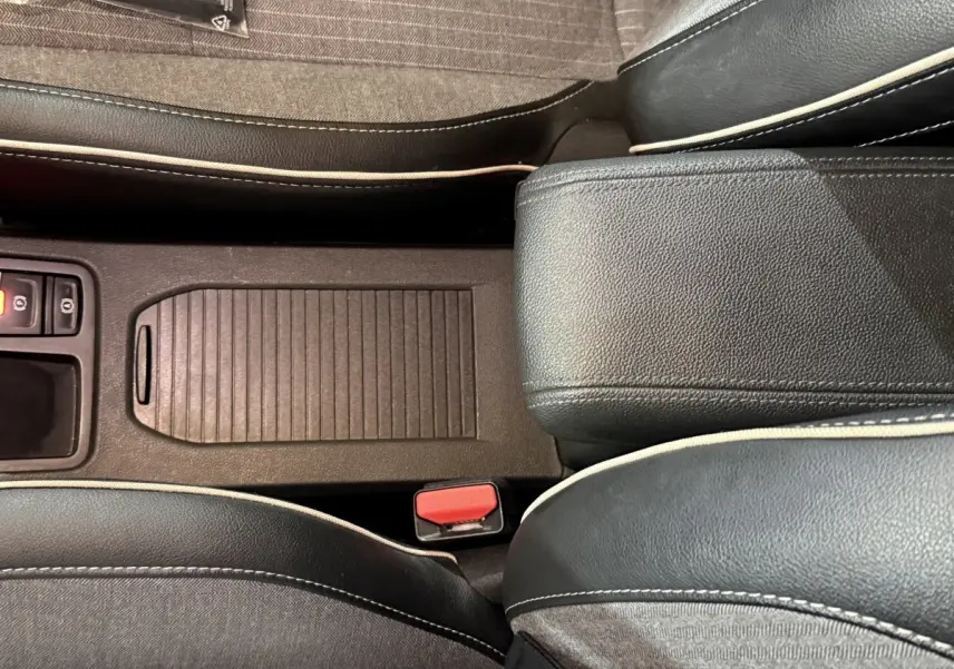 Vue rapprochée de la console centrale et des sièges noirs avec surpiqûres blanches de la Renault Clio Techno TCe 90 2024.