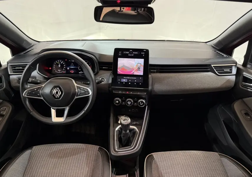 Vue intérieure frontale du tableau de bord et volant cuir noir de la Renault Clio Techno TCe 90, avec écran tactile vertical.