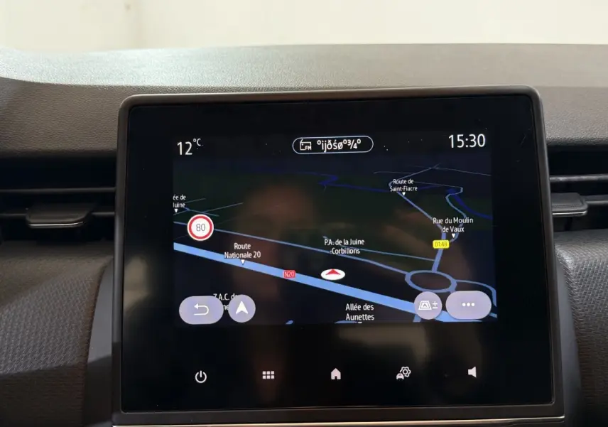 Écran tactile central du tableau de bord de la Renault Clio Business blanc, affichant la navigation GPS et la température extérieure.
