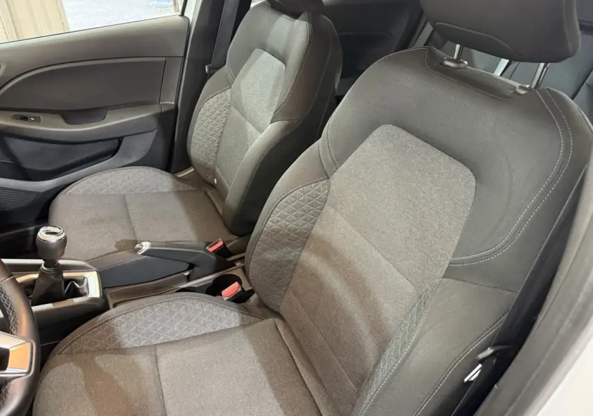 Vue intérieure côté conducteur de la Renault Clio Business 2021, sièges tissu gris avec console centrale et levier de vitesses manuel.