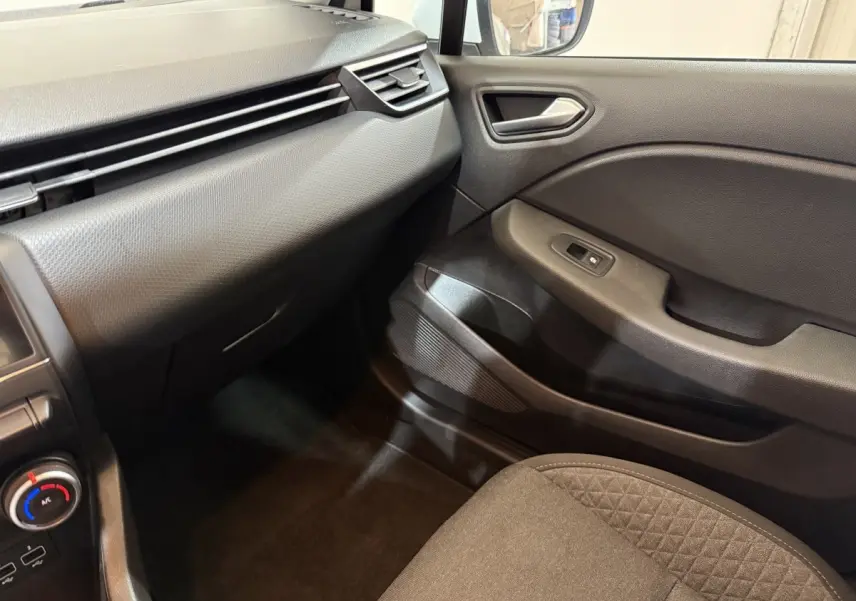 Vue intérieure côté passager avant de la Renault Clio Business SCe 65 2021, montrant la portière et la console en plastique noir.