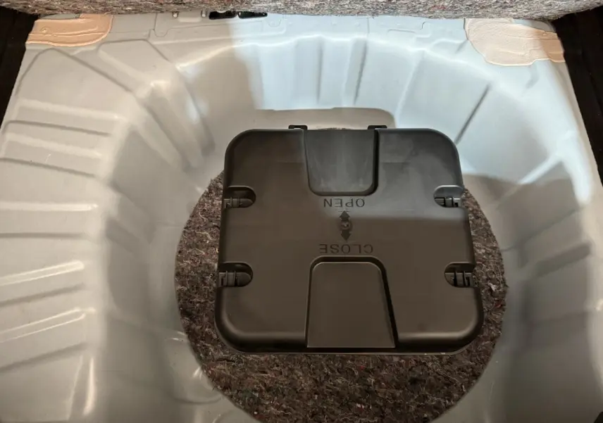 Vue plongeante sur le coffre blanc de la Renault Clio Business avec compartiment noir central marqué open/close.