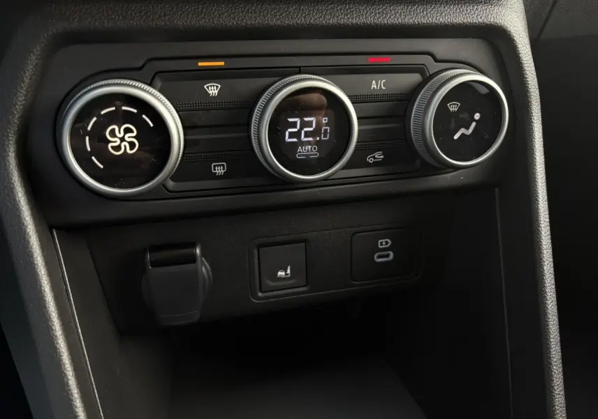 Gros plan sur les commandes de climatisation automatique du tableau de bord du Dacia Jogger Gris Urbain 2024.