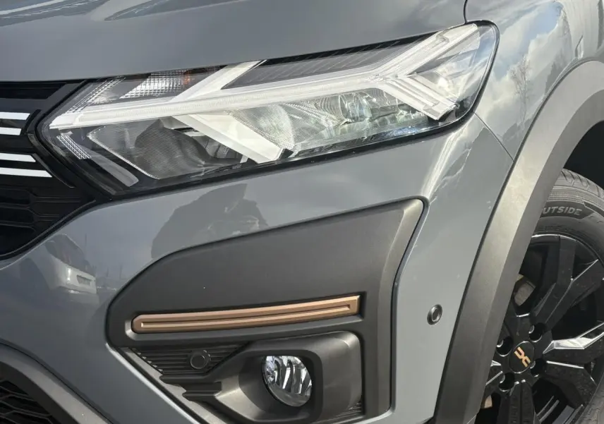 Gros plan sur le phare avant droit gris urbain du Dacia Jogger 2024 avec antibrouillard et jante noire distinctive.