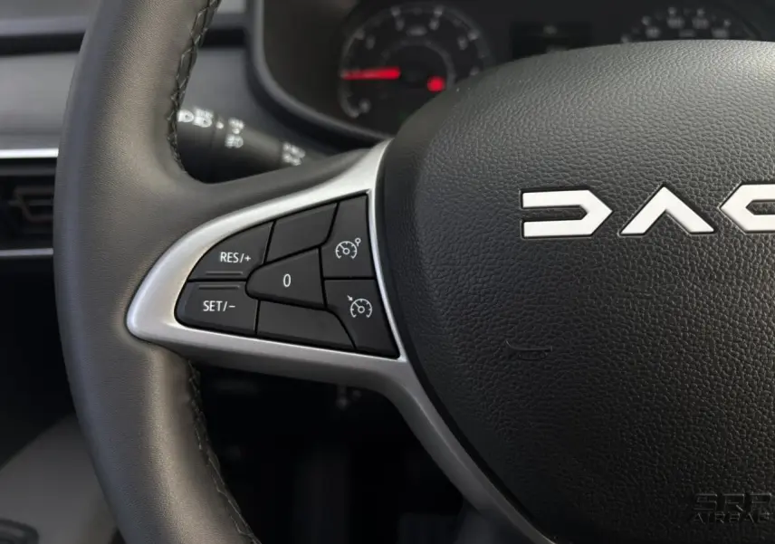 Gros plan sur le volant noir de la Dacia Jogger 2024 avec commandes de régulateur de vitesse à gauche.