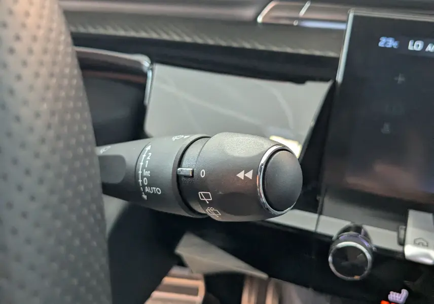 Gros plan sur la manette de commande d'essuie-glace dans l'habitacle gris noir du Peugeot 508 SW GT 2024.