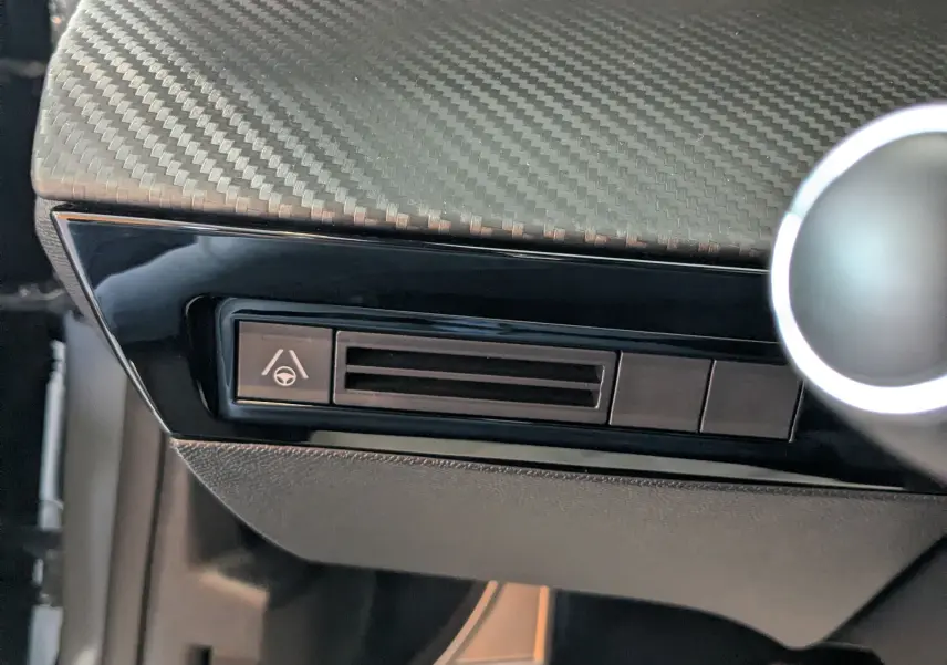 Détail de la console côté conducteur avec finition carbone et pédales aluminium dans un Peugeot 508 SW gris Selenium 2024.