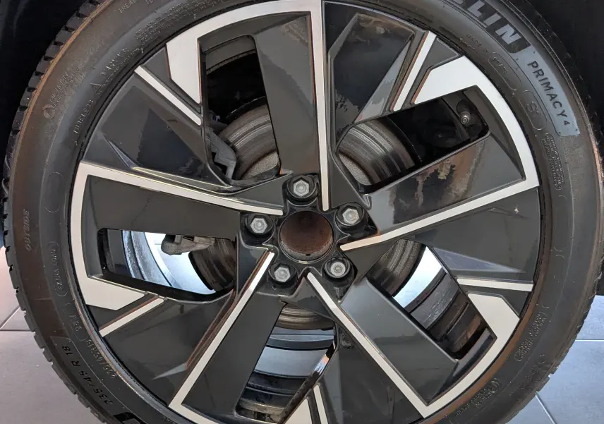 Gros plan sur la jante aluminium 18 pouces bicolore de la Peugeot 508 SW gris selenium de 2024.