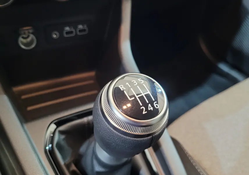 Le levier de vitesses manuel noir et argenté de la Renault Clio Evolution Blue dCi 100, vue rapprochée de l'intérieur.