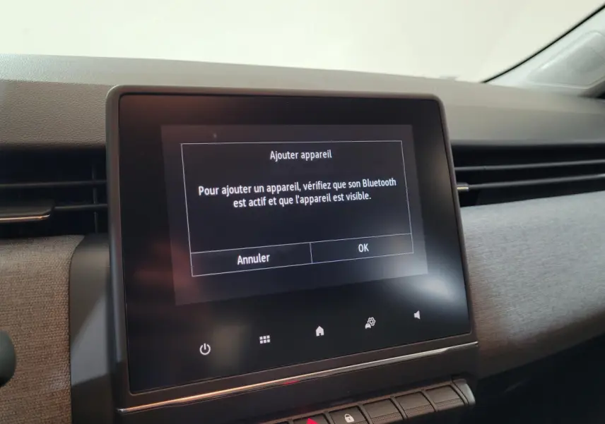 Écran tactile central affichant un message Bluetooth dans l'habitacle moderne d'une Renault Clio 2025.