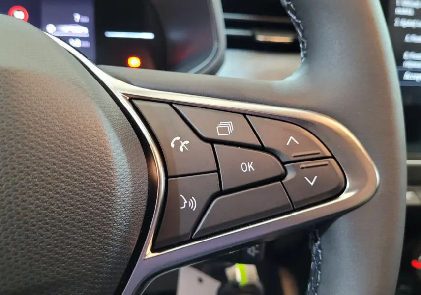 Gros plan sur les commandes multifonctions à droite du volant cuir de la Renault Clio Evolution Blue dCi 100 2025.