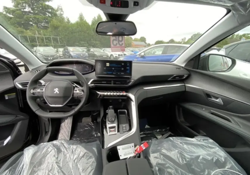 Intérieur avant du Peugeot 3008 2021 noir Perla Nera, tableau de bord moderne avec écran tactile et volant compact.