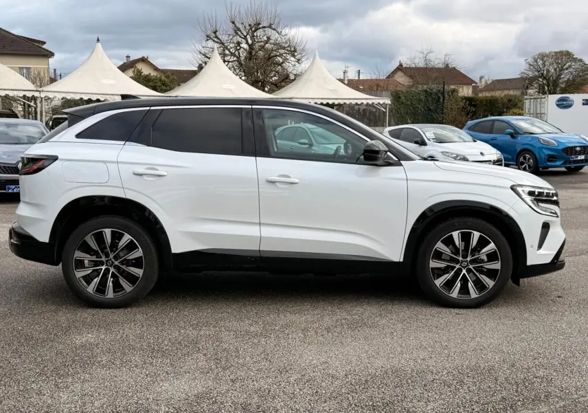 Profil côté gauche du Renault Austral E-Tech 200 blanc nacré avec toit noir, roues alliage et vitres teintées.
