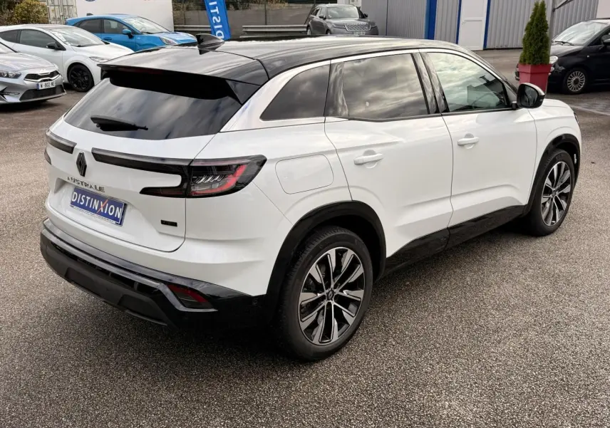 Vue 3/4 arrière droite du Renault Austral blanc nacré avec toit noir brillant et jantes alliage bicolores.