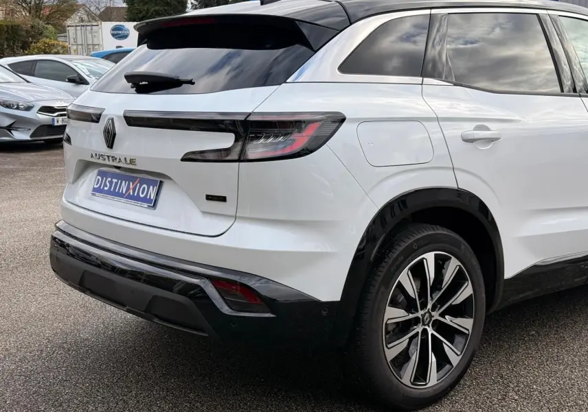 Vue 3/4 arrière droite du Renault Austral E-Tech 200 blanc nacré avec toit noir et jantes biton modernes.