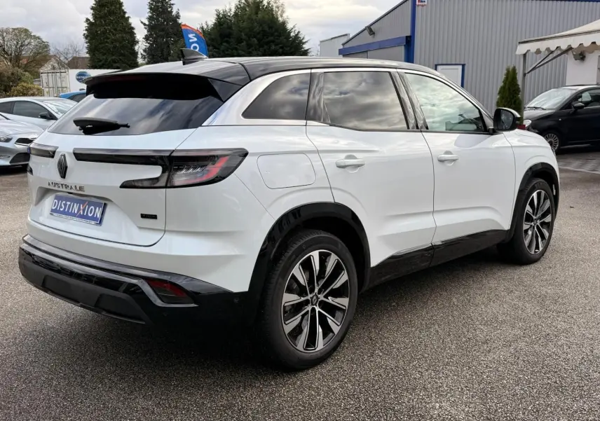 Vue 3/4 arrière droite du Renault Austral blanc nacré avec toit noir, jantes alliage et feux arrière LED distinctifs.